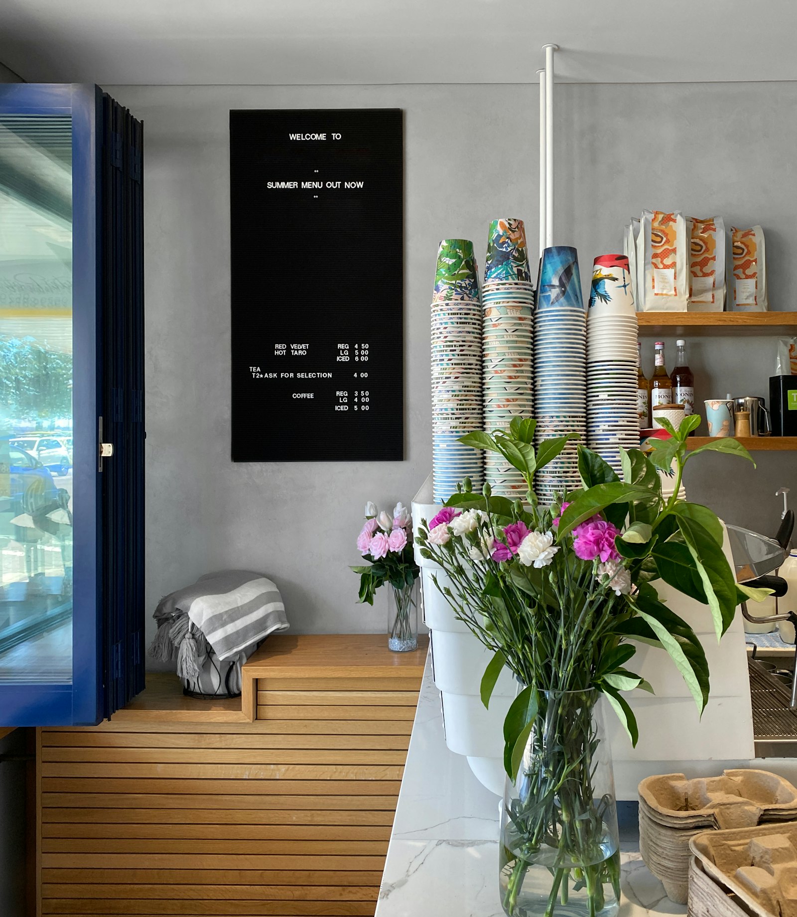 花とカップが並ぶ、明るい店内